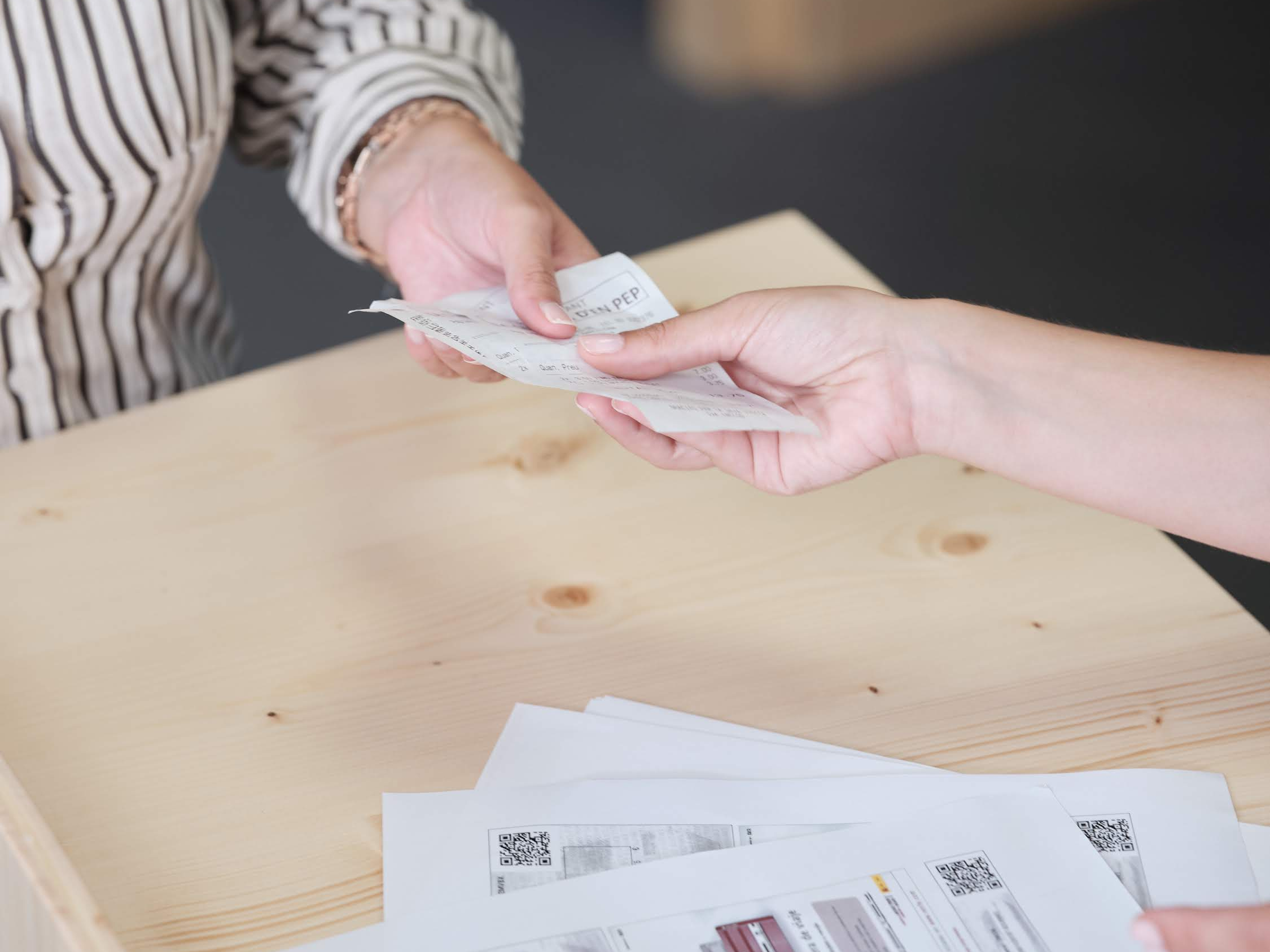  A close-up image of a business traveler handing a receipt to a corporate travel agent as part of an automated corporate travel policy compliance process.